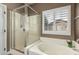 Relaxing bathroom retreat with a soaking tub and glass-enclosed shower at 14282 W Indianola Ave, Goodyear, AZ 85395