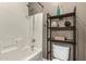 This bathroom is equipped with a shower-tub combo and decorative shelving for storage at 14282 W Indianola Ave, Goodyear, AZ 85395
