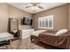 This bedroom features tile floors, a ceiling fan and a window with lovely plantation shutters at 14282 W Indianola Ave, Goodyear, AZ 85395
