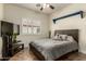 Comfortable bedroom with natural light, wood-look tile, and ceiling fan at 14282 W Indianola Ave, Goodyear, AZ 85395