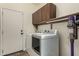Bright laundry room with washer, dryer, and upper cabinet storage space at 14282 W Indianola Ave, Goodyear, AZ 85395