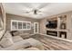 Comfortable living room with modern fireplace, wood-look flooring, large windows and neutral color palette at 14282 W Indianola Ave, Goodyear, AZ 85395