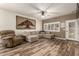 Inviting living room with neutral colors, wood-look floors, comfortable seating, and a unique tree wall art at 14282 W Indianola Ave, Goodyear, AZ 85395