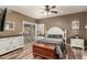 Beautifully decorated main bedroom with wood-look floors, a sliding glass door, and white furnishings at 14282 W Indianola Ave, Goodyear, AZ 85395