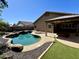 Serene backyard oasis with a freeform pool, covered patio, artificial turf, and plenty of room for outdoor enjoyment at 14282 W Indianola Ave, Goodyear, AZ 85395