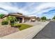 Wide street view showcasing a charming single-story home with a landscaped front yard and a paved driveway at 14282 W Indianola Ave, Goodyear, AZ 85395