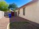 Side yard offers a mix of gravel and grass, plus a wooden gate, and storage with stucco home exterior at 1516 E Azalea Dr, Gilbert, AZ 85298