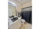 Modern bathroom featuring a black vessel sink, unique storage and a shower with a dark shower curtain at 1516 E Azalea Dr, Gilbert, AZ 85298