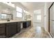 Bright bathroom with double vanity, dark wood cabinets, quartz countertop, and a walk-in shower at 15656 W Mercer Ln, Surprise, AZ 85379