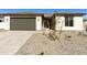 Charming single-story home featuring a two-car garage and low-maintenance desert landscaping in the front yard at 15656 W Mercer Ln, Surprise, AZ 85379