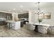 Bright kitchen and dining area with stainless steel appliances, a center island, and stylish pendant lighting at 15656 W Mercer Ln, Surprise, AZ 85379