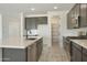 Modern kitchen featuring dark cabinets, stainless steel appliances, a large island and a walk-in pantry at 15656 W Mercer Ln, Surprise, AZ 85379