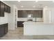 Modern kitchen featuring dark cabinetry, stainless steel appliances, a white backsplash, and a center island at 15656 W Mercer Ln, Surprise, AZ 85379