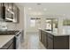 Open-concept kitchen with stainless appliances, dark cabinets, and a view into the living area at 15656 W Mercer Ln, Surprise, AZ 85379