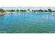 A tranquil lake featuring a fountain, surrounded by trees and walking paths at 15656 W Mercer Ln, Surprise, AZ 85379