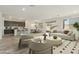 Open-concept living room featuring modern furniture, a neutral color palette, and abundant natural light at 15656 W Mercer Ln, Surprise, AZ 85379