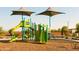 Playground featuring slides, climbing wall, and play structures on a wood chip surface at 15656 W Mercer Ln, Surprise, AZ 85379