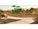 Playground with swings, slides, picnic tables, and benches in a park setting at 15656 W Mercer Ln, Surprise, AZ 85379