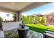 Relaxing outdoor living space featuring a stylish patio, lush green turf, and privacy landscaping at 17168 W Mountainair St, Surprise, AZ 85388