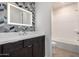 Bathroom with double vanity, herringbone tile accent wall and walk-in shower at 17168 W Mountainair St, Surprise, AZ 85388