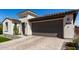 Modern home exterior with a two-car garage, stone accents, and well-maintained landscaping in a desert environment at 17168 W Mountainair St, Surprise, AZ 85388