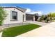 Well-maintained front yard with artificial turf, desert landscaping, and a paver driveway leading to a modern home at 17168 W Mountainair St, Surprise, AZ 85388