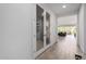 Bright hallway featuring glass-paneled doors, tile flooring, and views into the living room and backyard at 17168 W Mountainair St, Surprise, AZ 85388