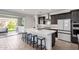 Stylish kitchen featuring a large island with seating, stainless hood, and tile flooring at 17168 W Mountainair St, Surprise, AZ 85388