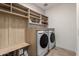 Laundry room features side-by-side washer and dryer, custom shelving and cabinets at 17168 W Mountainair St, Surprise, AZ 85388