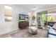 Cozy living room with a large window, TV, stylish furniture, and access to the outdoor patio at 17168 W Mountainair St, Surprise, AZ 85388
