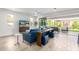 Bright living room with a modern sofa, TV, and sliding glass doors leading to an outdoor entertaining space at 17168 W Mountainair St, Surprise, AZ 85388