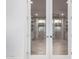 Bright office with glass french doors features built-in shelving, three windows, and tile flooring at 17168 W Mountainair St, Surprise, AZ 85388