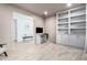 Bright office features built-in shelving, computer desk, tile flooring, and neutral paint scheme at 17168 W Mountainair St, Surprise, AZ 85388