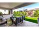 Covered patio featuring modern furniture, artificial turf, and manicured hedges at 17168 W Mountainair St, Surprise, AZ 85388