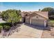 View of front exterior with a two car garage, neutral paint, desert landscaping, and mature shade trees at 1754 W San Tan St, Chandler, AZ 85224