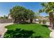 Inviting front exterior featuring lush green grass, mature trees, and a well-maintained facade at 1754 W San Tan St, Chandler, AZ 85224