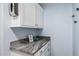 Bright laundry room with granite counters and white cabinets at 1754 W San Tan St, Chandler, AZ 85224