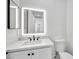 Bathroom showcasing a lighted mirror over a vanity and a tiled wall behind the toilet at 18225 W San Juan Ct, Litchfield Park, AZ 85340