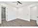 Bright bedroom with wood-look tile flooring, ceiling fan, and ensuite bathroom at 18225 W San Juan Ct, Litchfield Park, AZ 85340