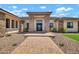 Inviting home entrance with stone pillars, a brick pathway, and modern glass doors at 18225 W San Juan Ct, Litchfield Park, AZ 85340