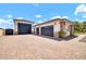 Modern garages with dark doors, side lighting, and paved driveway at 18225 W San Juan Ct, Litchfield Park, AZ 85340