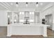 Well-lit kitchen offers a center island, range hood, custom cabinetry, and sleek countertops at 18225 W San Juan Ct, Litchfield Park, AZ 85340