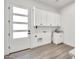 Bright laundry room features white cabinetry, a utility sink, and exterior door access at 18225 W San Juan Ct, Litchfield Park, AZ 85340