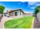 A well-maintained backyard features a strip of green grass and a stone walkway at 1835 E Marquette Dr, Gilbert, AZ 85234