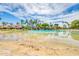 Expansive community pool with sandy beach area, palm trees, and clear blue water under sunny skies at 1835 E Marquette Dr, Gilbert, AZ 85234