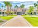 Grand exterior view of a palatial home with lush landscaping and towering palm trees, showcasing luxury living at 1835 E Marquette Dr, Gilbert, AZ 85234