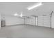 Well-lit two car garage with ample parking space and storage, featuring a modern door opener and neutral paint at 1835 E Marquette Dr, Gilbert, AZ 85234