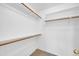 Spacious walk-in closet with wooden hanging rails and shelving plus carpeted floor at 1835 E Marquette Dr, Gilbert, AZ 85234