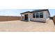 An empty backyard featuring a covered patio with sliding glass doors, complemented by dark window frames at 20326 W Roma Ave, Buckeye, AZ 85396