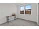 Minimalist bedroom with neutral carpet, bright windows, and modern accent table at 20326 W Roma Ave, Buckeye, AZ 85396